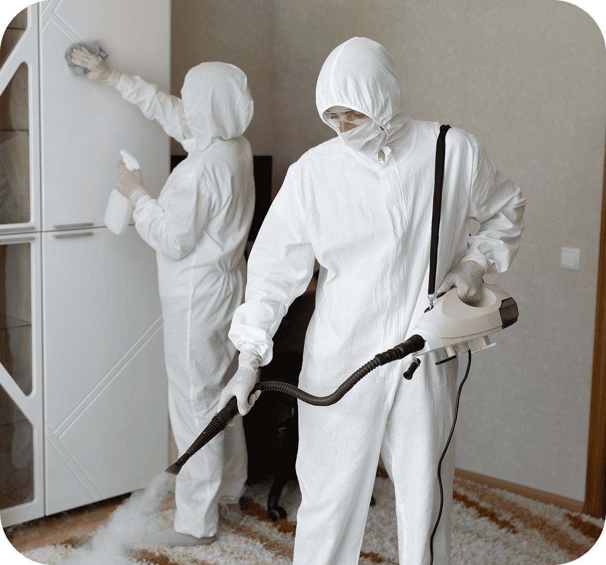 People in protective suits cleaning indoors.