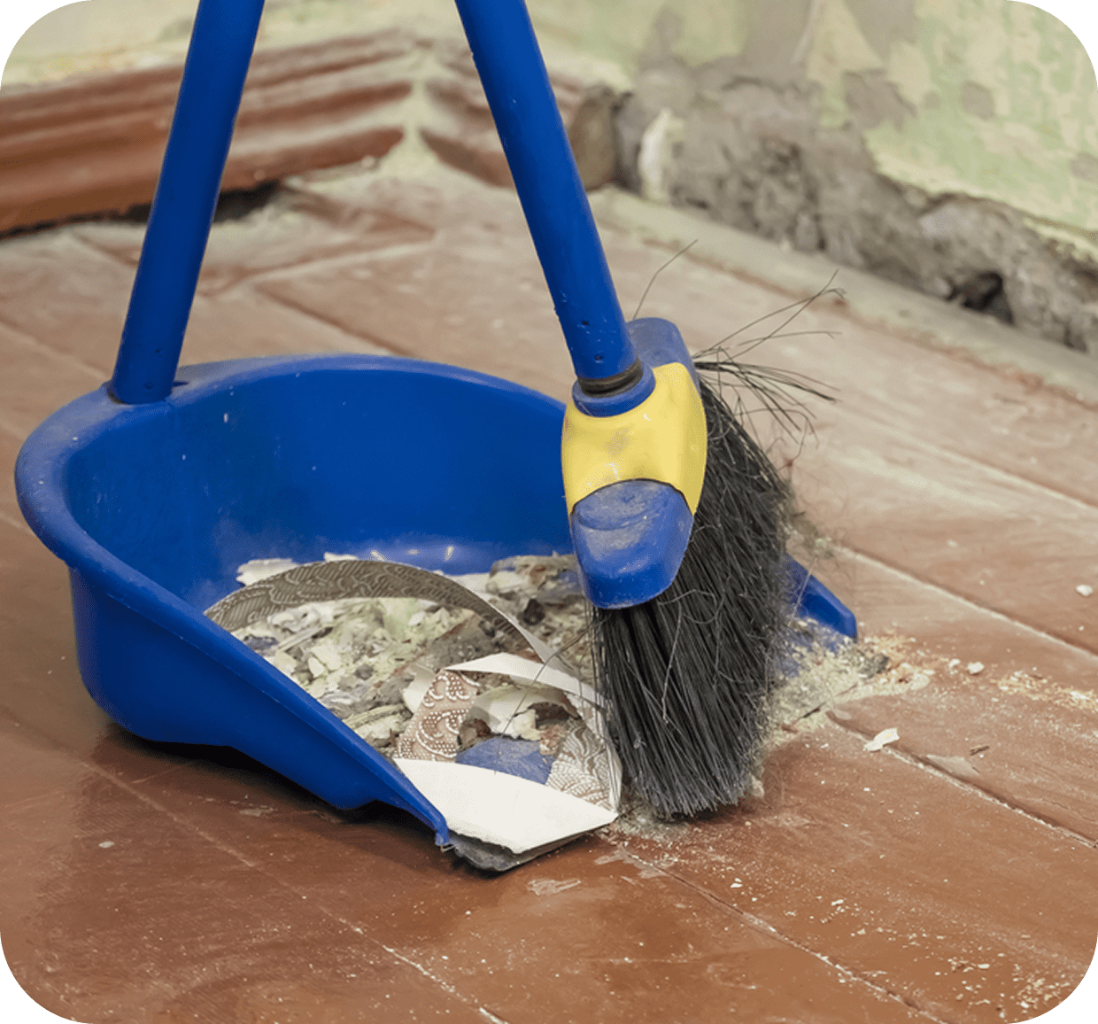 Broom and dustpan with construction debris.